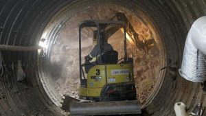 Miniescavadeira, chapas de aço e concreto projetado compõem a base dos túneis do Drenar DF